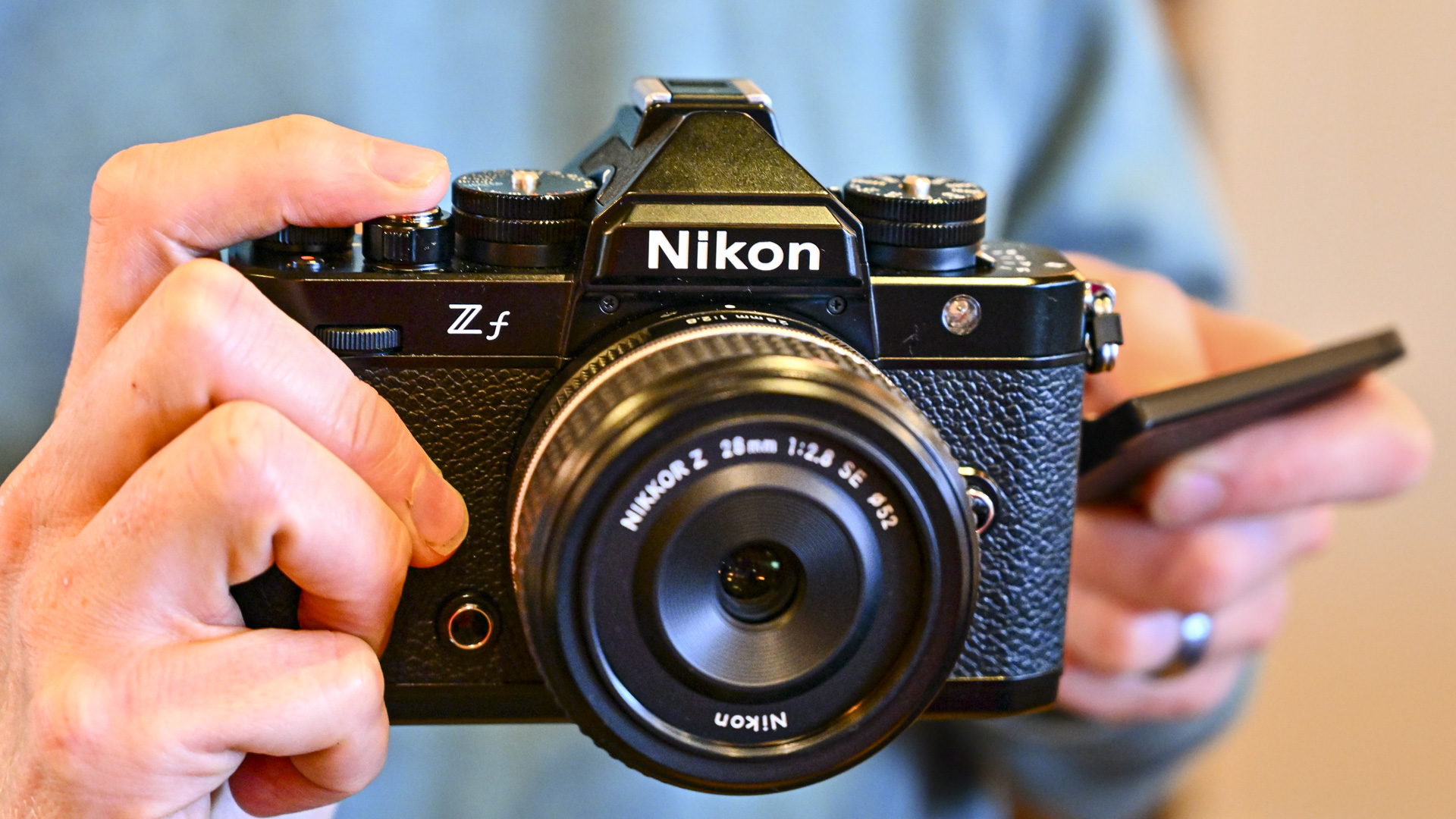 Nikon Zf camera in the hand with Z 28mm F2.8 SE lens attached