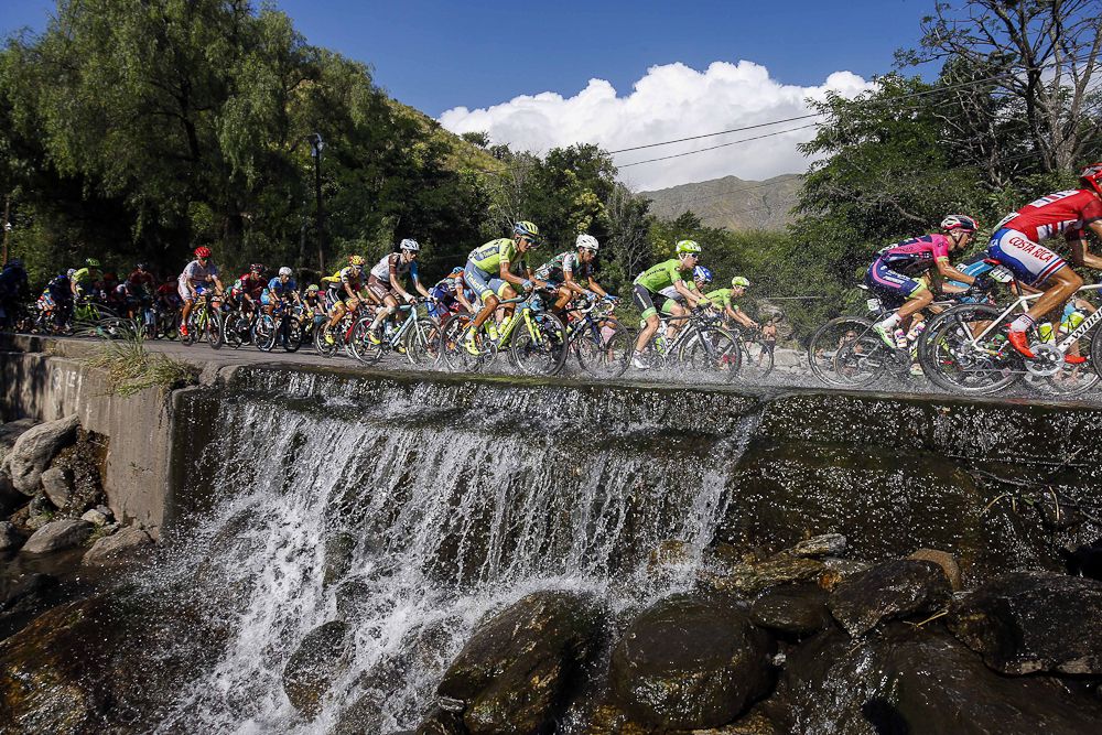 Riders make their way through a wet patch during stage 6.