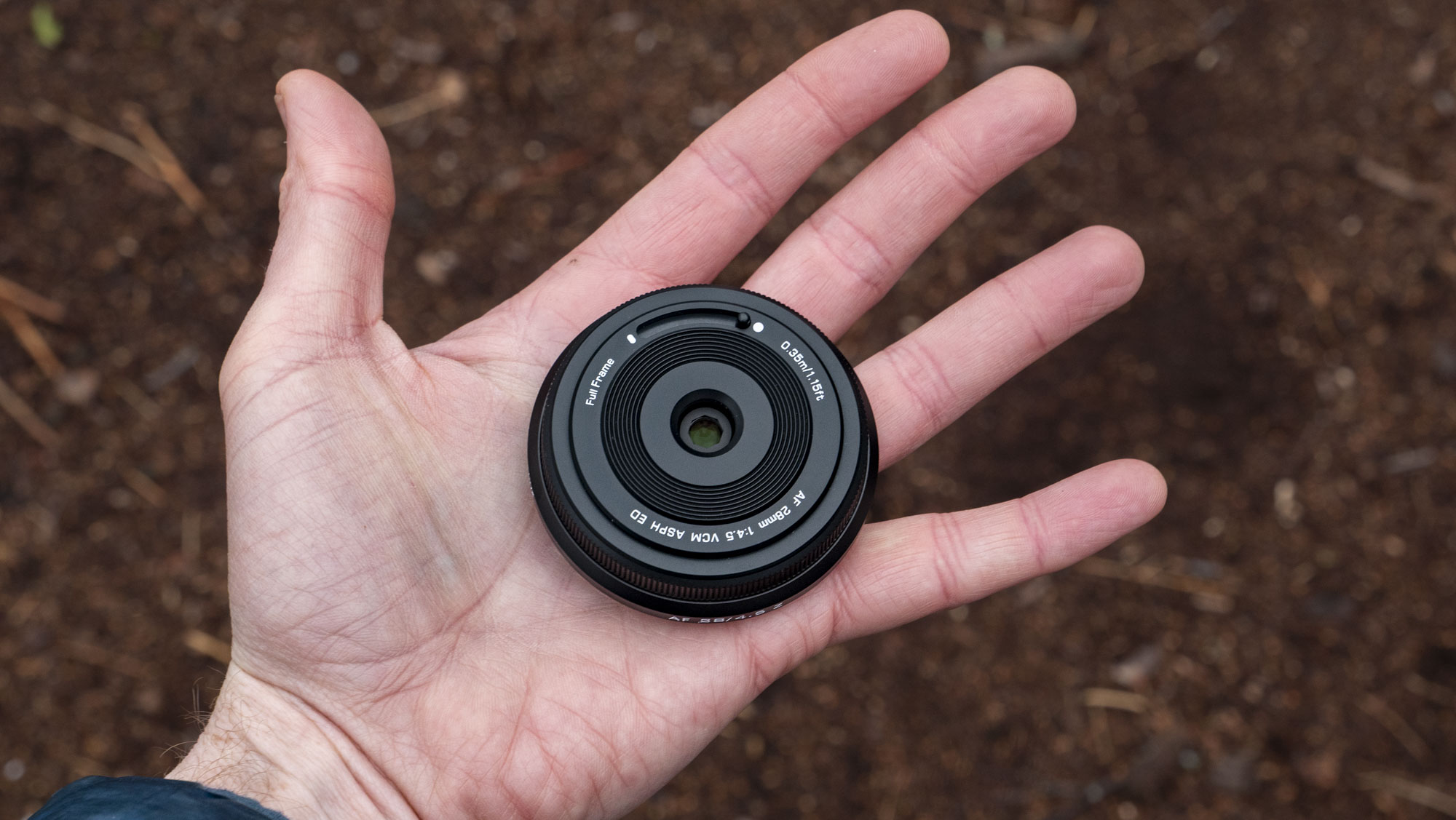 Viltrox AF 28mm f/4.5 body cap lens in photographer's hand