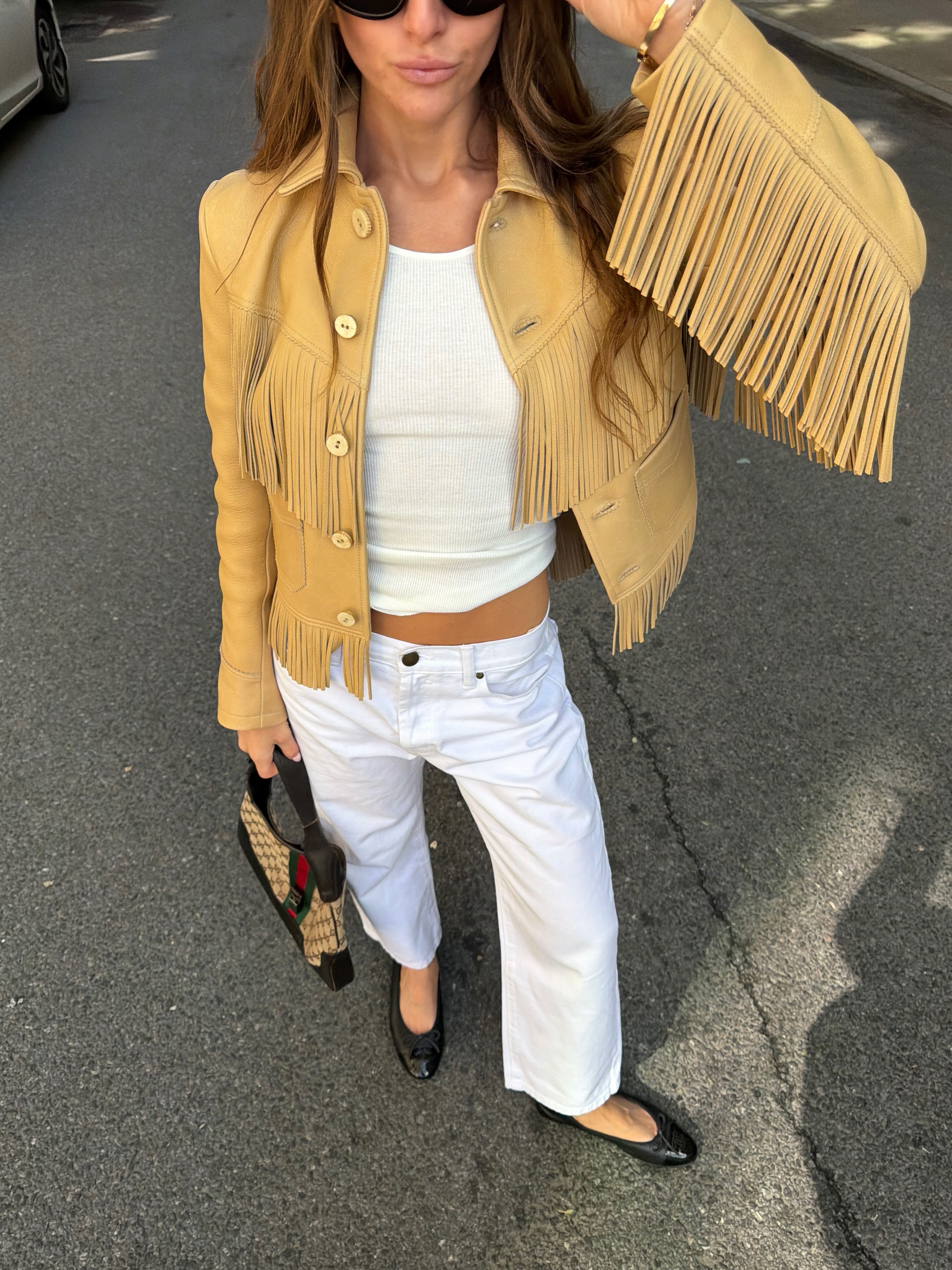 Woman in white jeans, tank top and fringe jacket