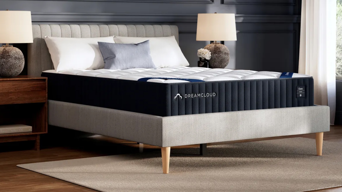 DreamCloud Classic Hybrid Mattress on a gray platform bed frame between two end tables with lamps