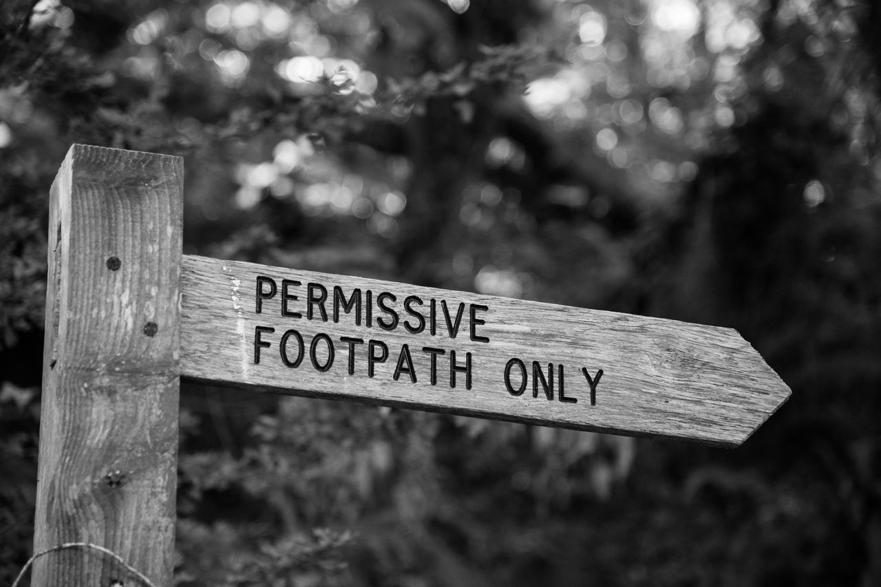 A black-and-white image of a sign that says Permissive Footpath Only