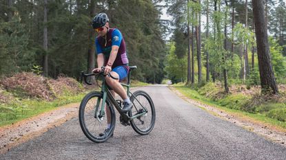 Best cycling jersey: rider interacting with the Garmin Edge 540 Solar head unit on a forest road