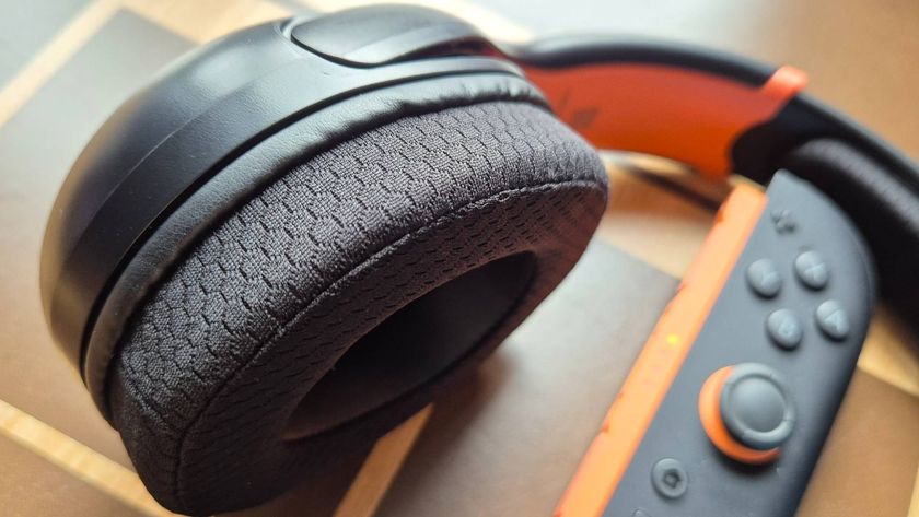 Photo of a close up of one of the ear cups of the Airlite Fit headset. A Joy-Con 2 controller is sitting to the right hand side of the headset.