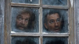 L to R: Kenneth Branagh as Nikolai Ustinov and Ryan Reynolds as Troy Kelly looking out of a frosted windown in Mayday
