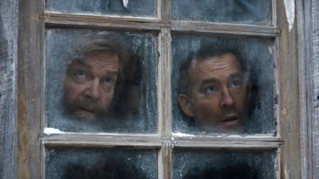 L to R: Kenneth Branagh as Nikolai Ustinov and Ryan Reynolds as Troy Kelly looking out of a frosted windown in Mayday