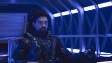 The Expanse – still from TV show with Steven Strait as James Holden in pilot chair (blue lighting)