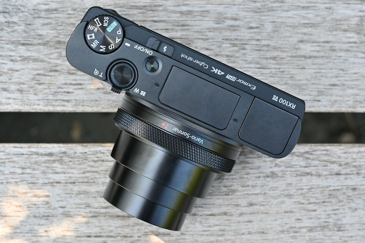 Top down view of the Sony RX100 VII on a wooden surface outdoors, with its lens extended