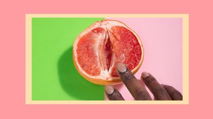 Cropped Hands Of Person Touching Grapefruit Over Two Tone Background