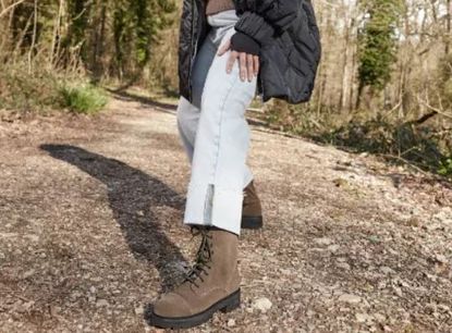 Woman striding in a woodland in walking boots