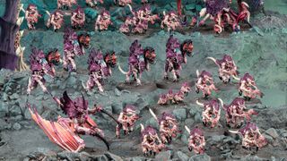The alien warriors of the Tyranids stand scattered across a cliff-face