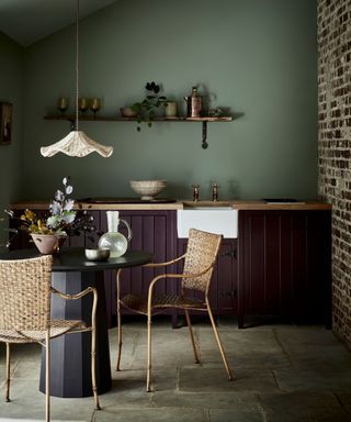 Dark kitchen with cute round table and chairs in foreground
