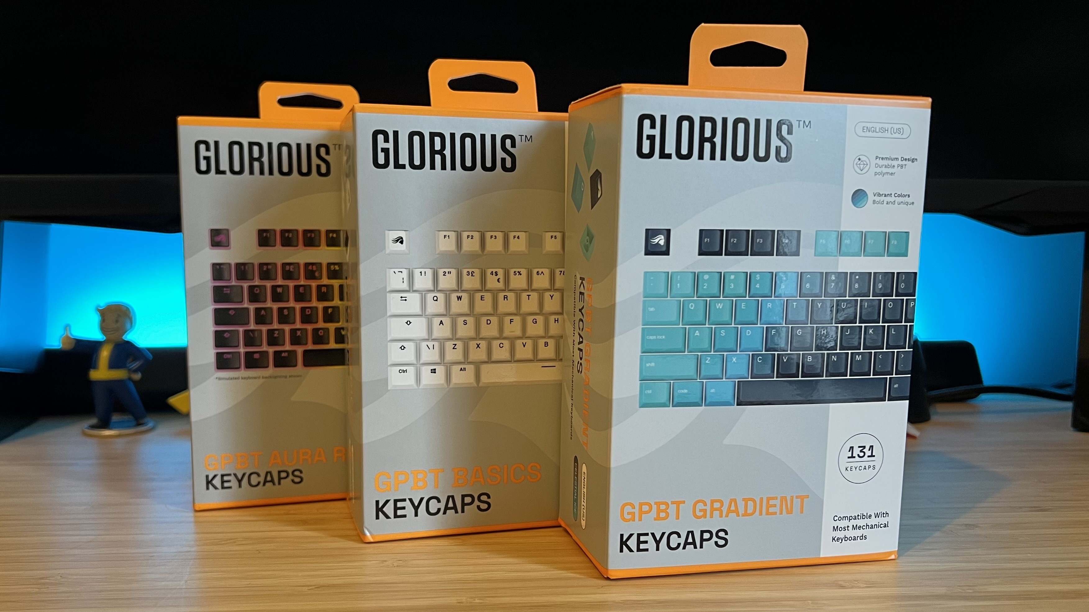 Glorious GPBT keycap boxes on a wooden desk