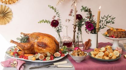 A roast turkey chosen using a turkey size calculator on a table laid for Christmas and Thanksgiving dinner