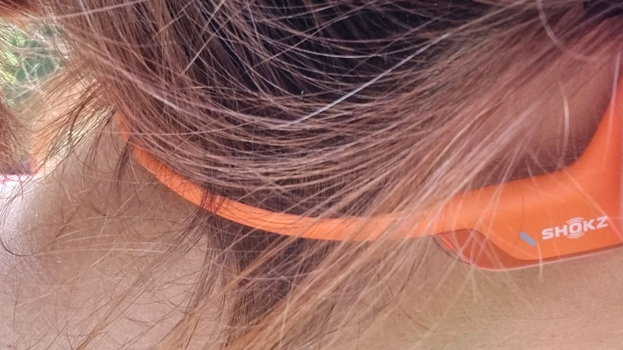 A close-up picture of our reviewer wearing the Shokz OpenRun Pro 2 bone conduction headphones