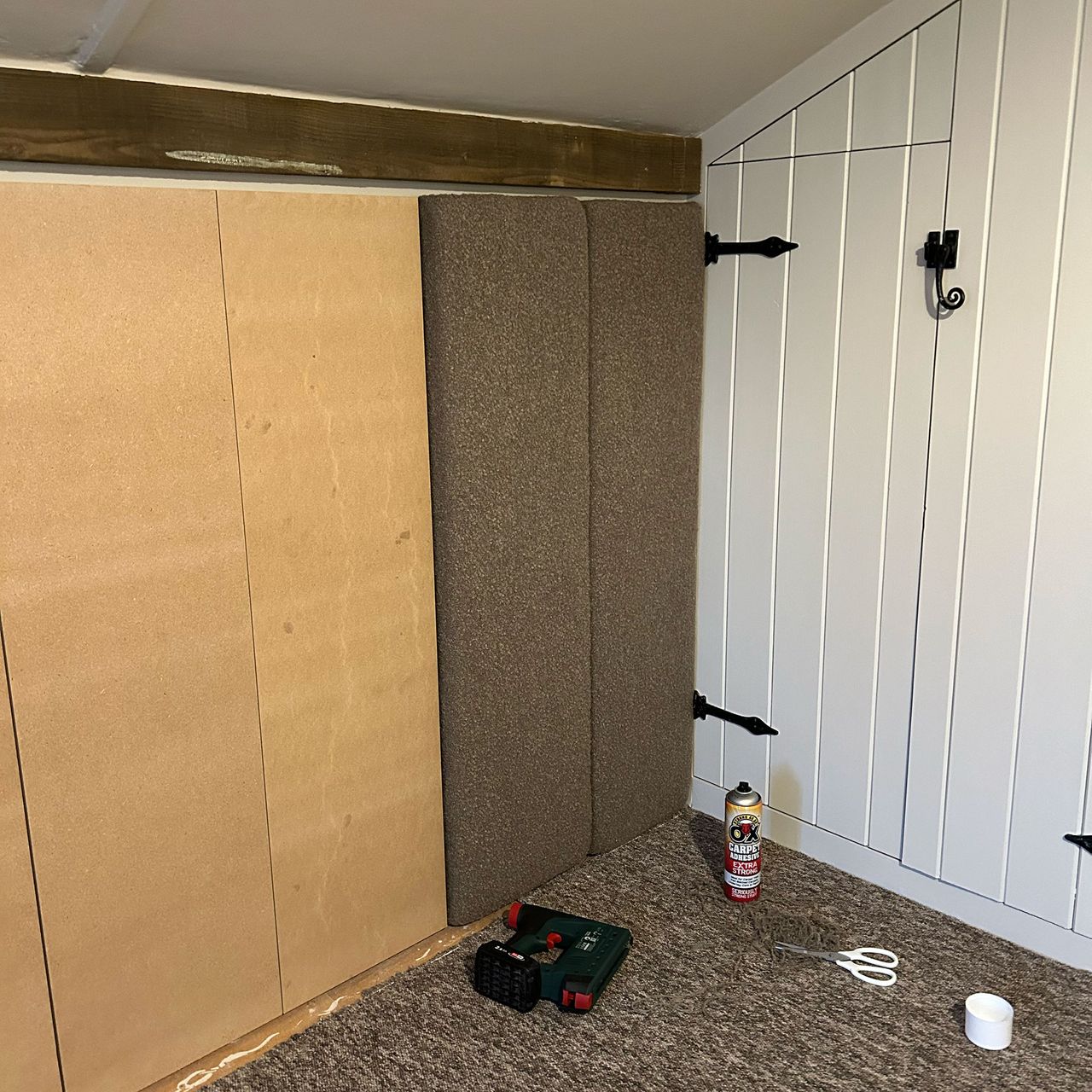Upholstered panelled headboard being put into place on wall
