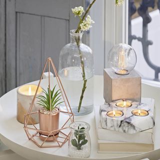 room with concrete lightbulb marble tealight holder and white table