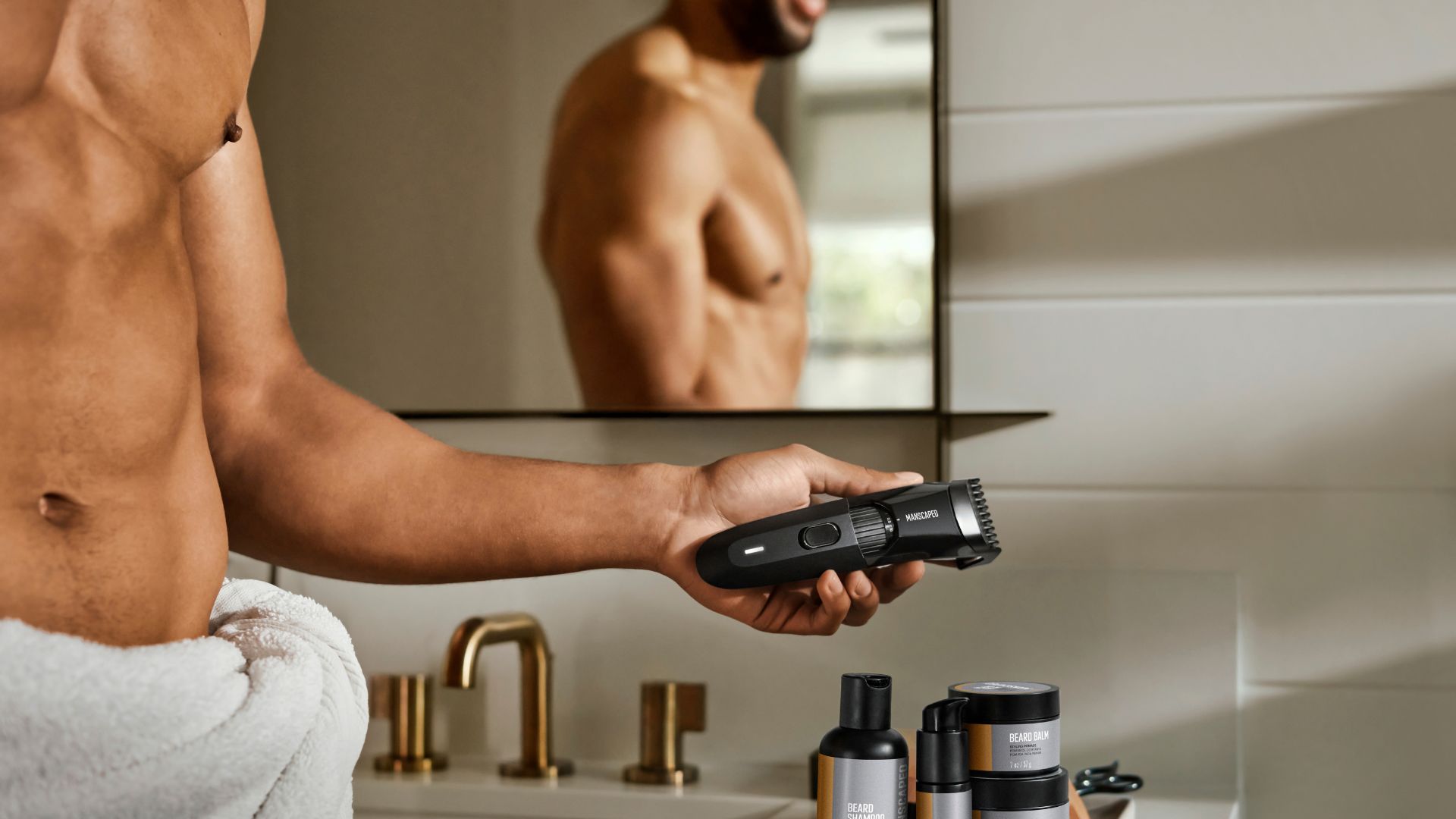 an image of a man in a towel holding a manscaped razor