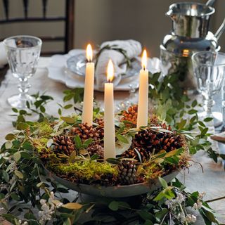 Christmas table centrepiece with pine cones and candles