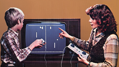 An adult and child play the Home Pong video game
