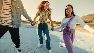 Three people holding hands and laughing