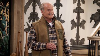 Kelsey Grammer wearing plaid shirt and brown vest over it while holding a drinking glass in his hand