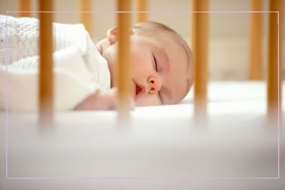 A baby asleep in a cot