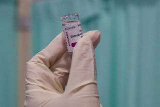 A member of NHS staff prepares the Oxford AstraZeneca vaccine