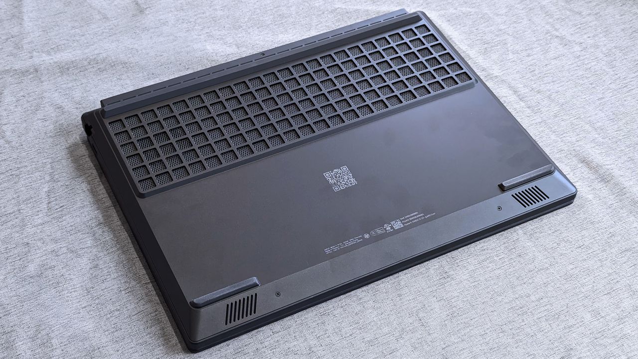 The underside of a HyperX OMEN 15 laptop showing a large rectangular ventilation grille, smaller corner vents, rubber feet, regulatory markings, and a centered QR code.