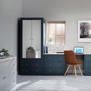 White bedroom with dark grey fitted furniture including a mirrored wardrobe and desk