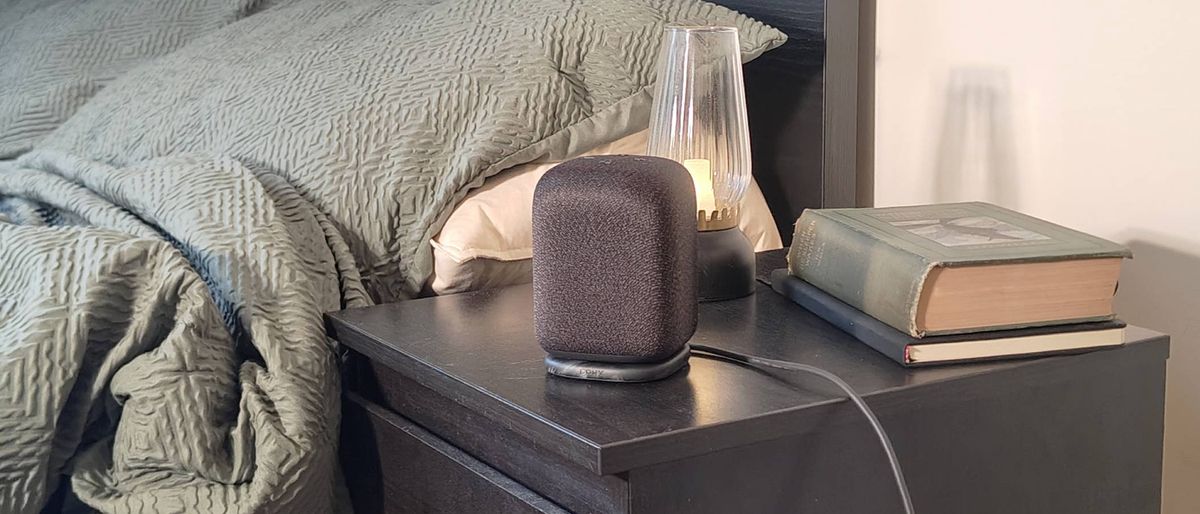 The Sony LinkBuds Speaker on a shelf beside a bed.