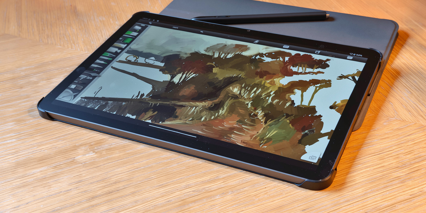 A black Android drawing tablet on a wooden table