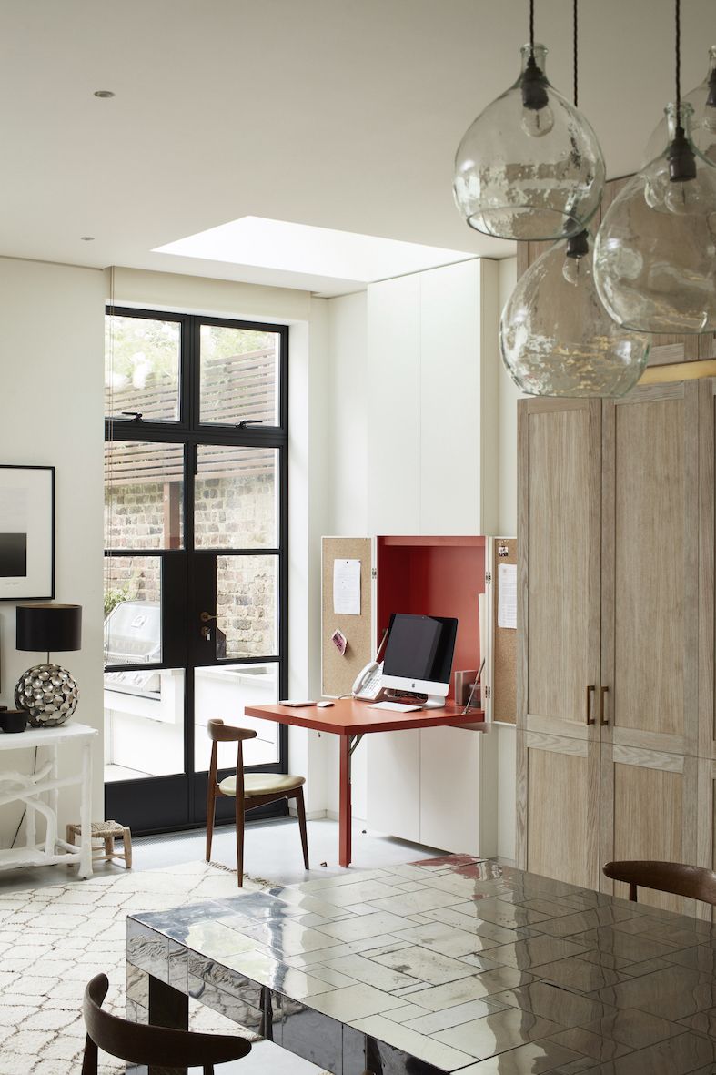 drop down desk with red interior next to Crittall doors