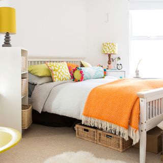 bedroom with white wall cream colour flooring white bed with colourful cushions and lamps