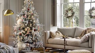 neutral living room with snowy Christmas tree decorating idea with oversized star lights and animal decorations
