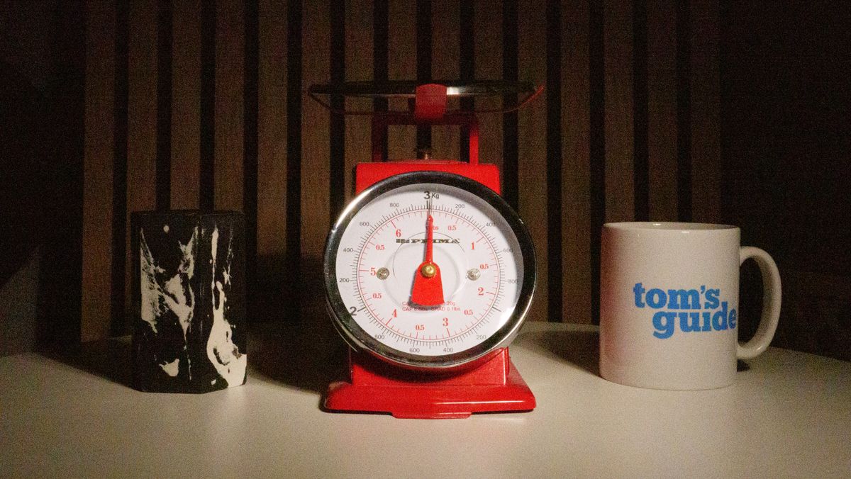 A photo of a set of red scales next to a Tom's Guide mug