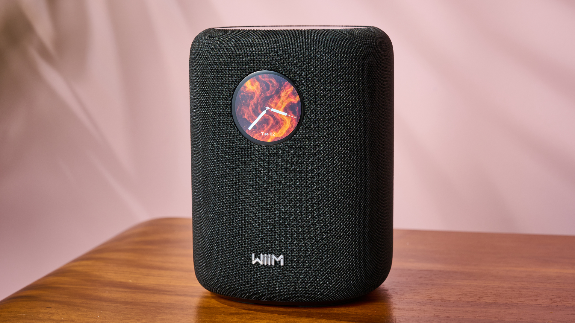 The WiiM Sound from the front &amp;ndash; its screen shows a clock on a firey background.