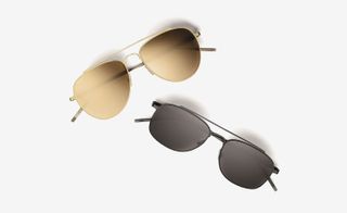 View of two pairs of Tomas Maier aviator sunglasses in different colours pictured against a light grey background