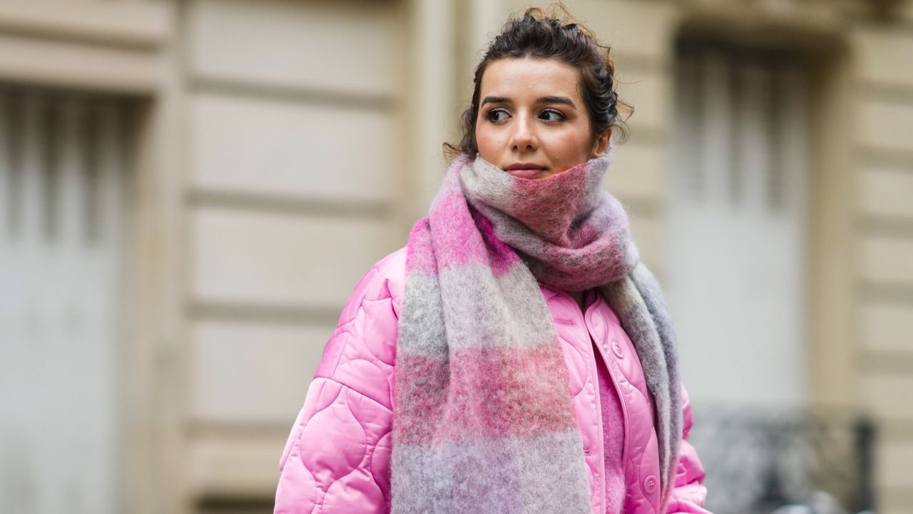 woman wears pink wool blanket scarf