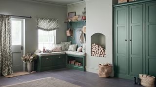 boot room with fitted green furniture and open fire filled with logs