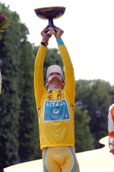 Three-time Tour champion Alberto Contador holds the winner's trophy high.