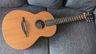 A Sheeran by Lowden W05 acoustic guitar lying on a sofa