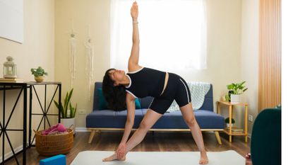 woman does triangle yoga pose at home