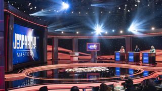 Victoria Groce, Matt Amodio and Adriana Harmeyer behind their podiums on the Jeopardy! Masters stage