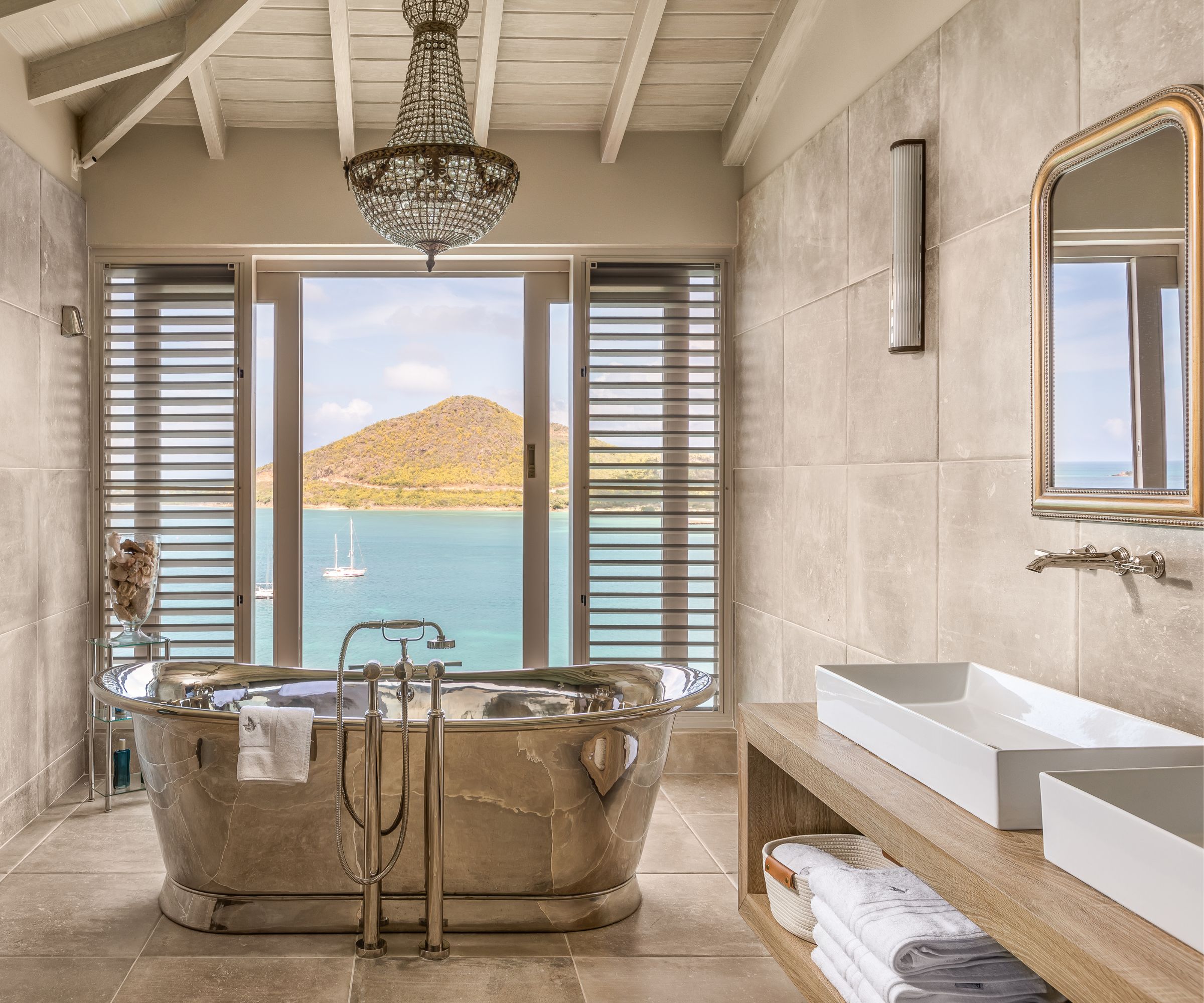 Silver bath, white twin sinks, tiled walls and floor, French windows