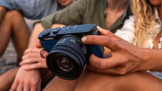 Panasonic Lumix S 18-40mm f/4.5-6.3 lens attached to a camera and held in a pair of hands