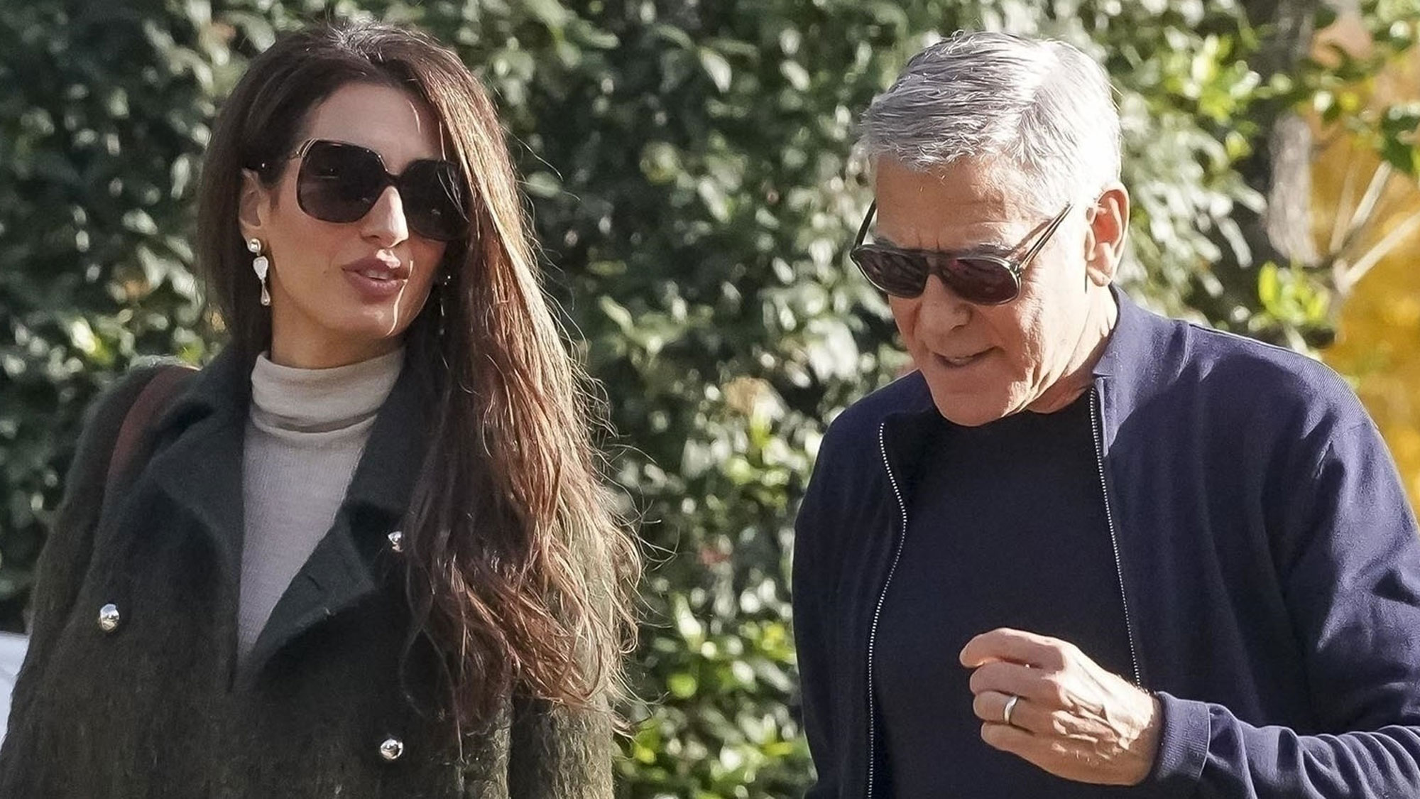 Amal Clooney wears a green coat and black tights in France in December 2025