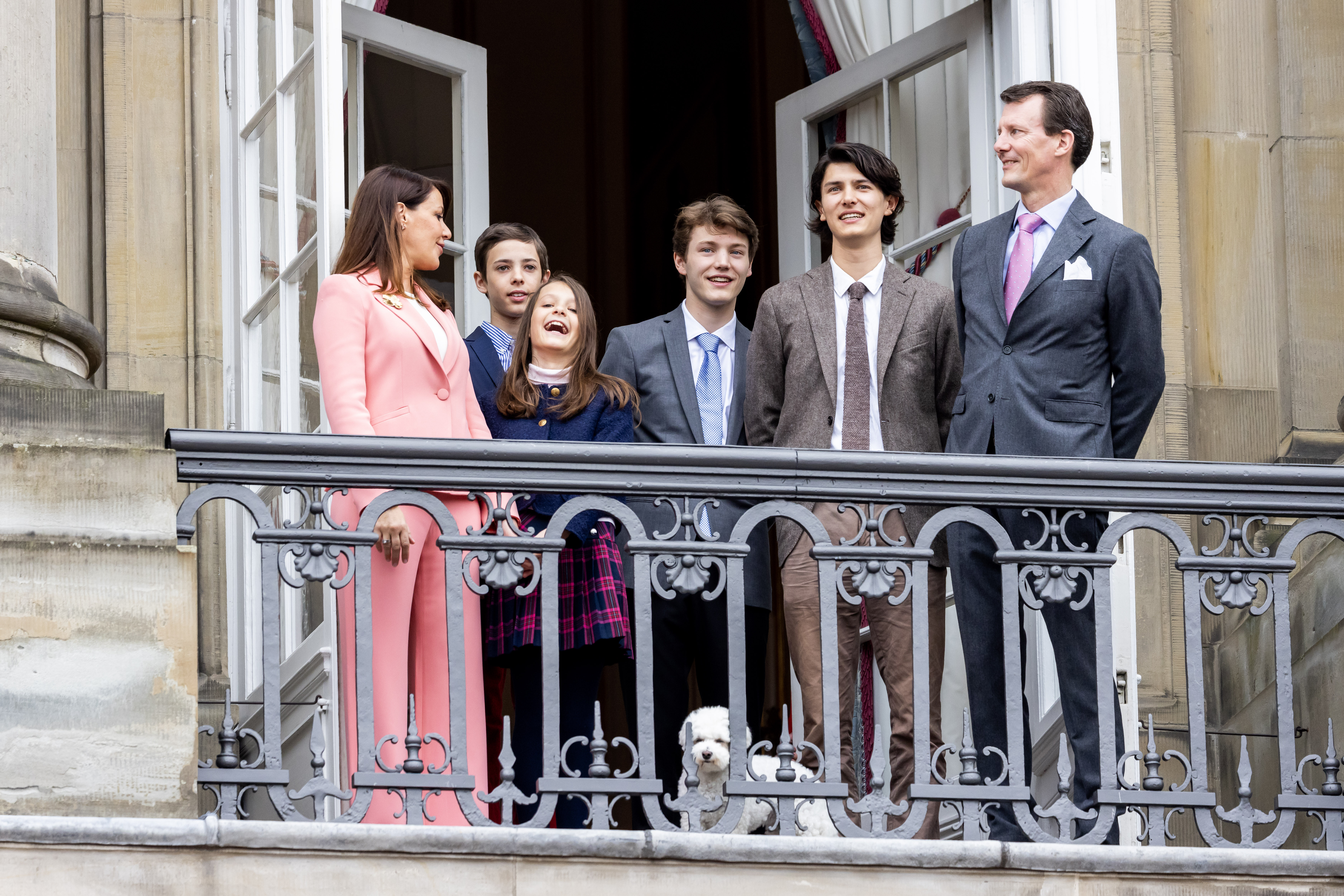 Princess Marie, Prince Joachim and their four kids and dog standing on a palace balcony