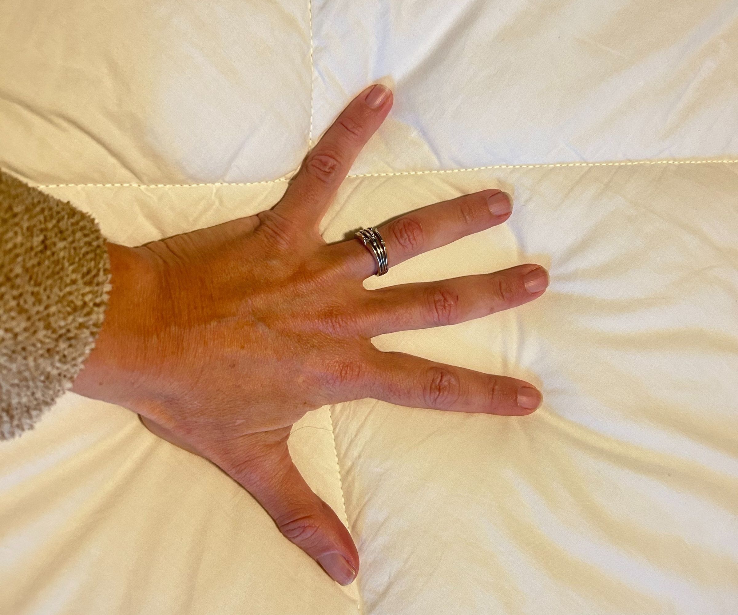 A hand pressing down on a comforter