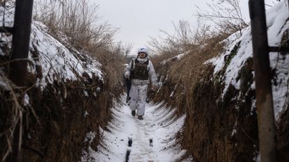 A Ukrainian soldier patrols a trench outside Verkhnotoretske, Ukraine